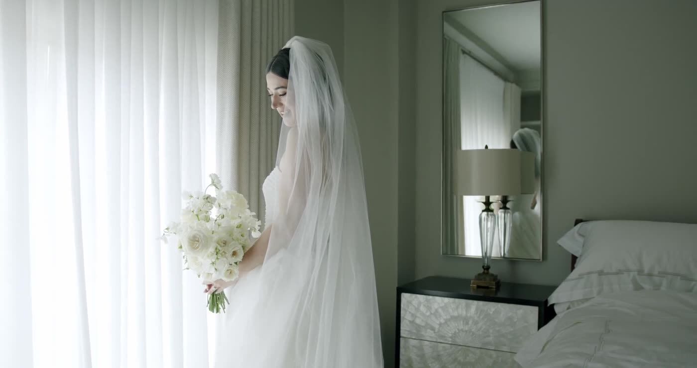 A bride in her veil by a bright window